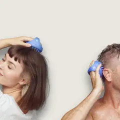 En kvinna och en man njuter av en avslappnande scalp massage med blåa borstar.
