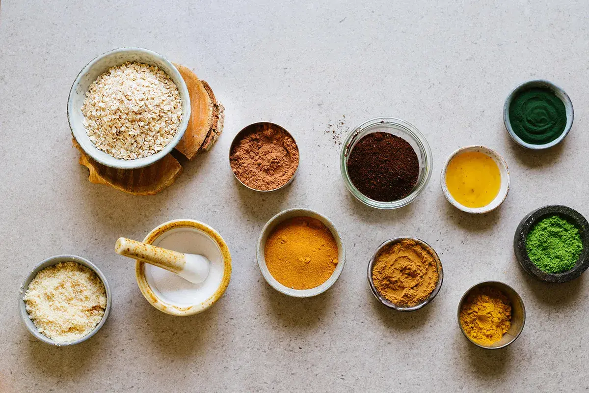 Ingredienser för en hemmagjord hårbottenskrubb: havre, kakao, kaffe, gurkmeja, spirulina och olja.