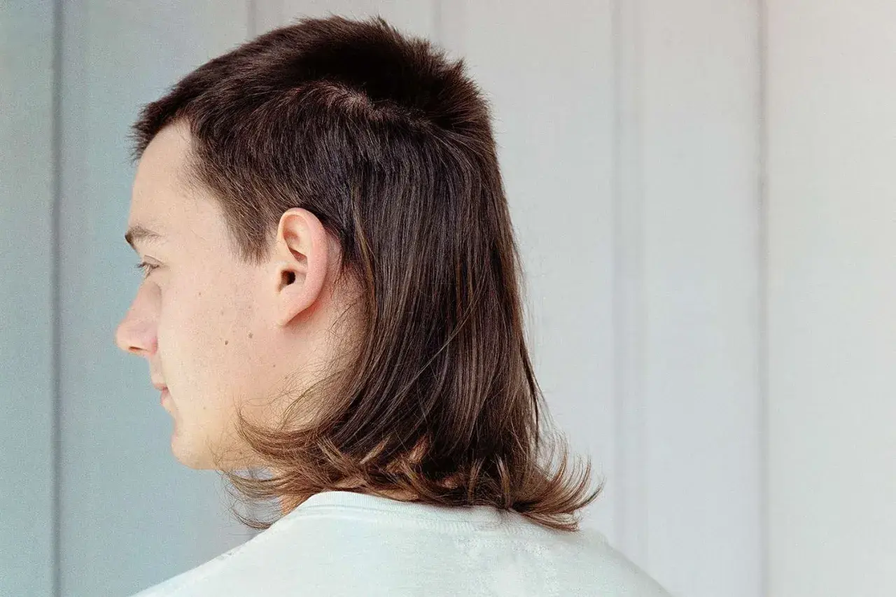 En tjej med en modern mullet frisyr, kortklippt upptill och längre i nacken.